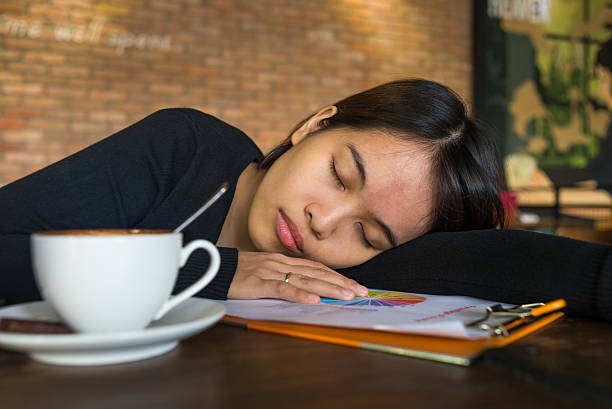 asian dziewczyna zasnąć na dokumencie obok kubek kawy - document file emotional stress paperwork zdjęcia i obrazy z banku zdjęć