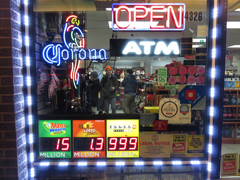 Washington DC, USA-January 13, 2016: This Liquor store with electronic Powerball sign was spotted in Northwest Washington DC. It is advertising several lotteries including the Powerball which now stands at 1.5 billion dollars.  Customer inside the store are either purchasing liquor and or lottery tickets.