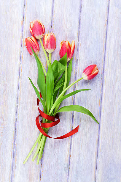 tulipanes rojos sobre púrpura mesa de madera - table wedding flower bow fotografías e imágenes de stock