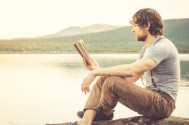 istock Young Man reading book outdoor Summer vacations Lifestyle 504782067