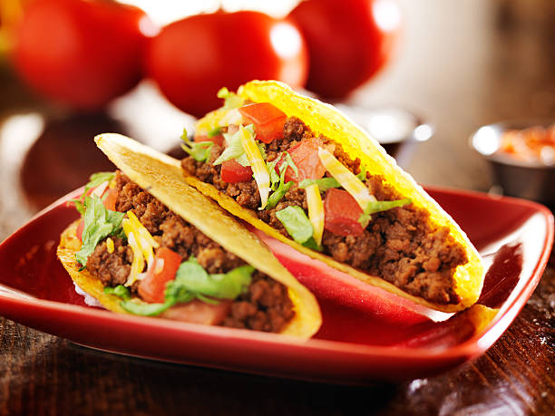 istock two beef hard shell tacos with cheese, lettuce and tomatoes 504782723