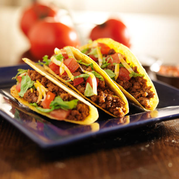 istock three beef tacos with cheese, lettuce and tomatoes 504782725
