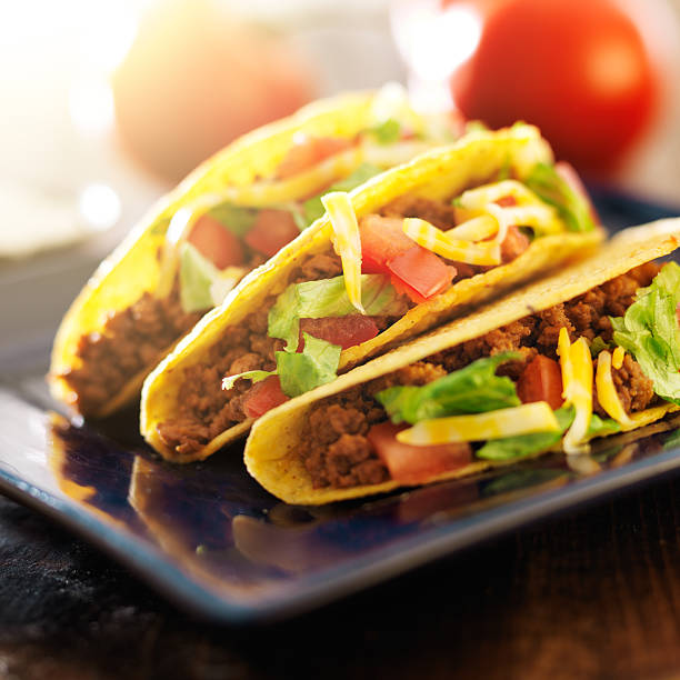 istock three beef tacos with cheese, lettuce and tomatoes 504782731
