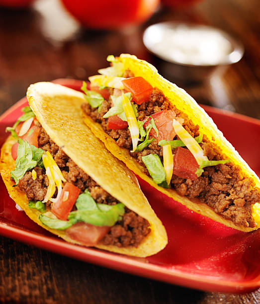 istock two beef tacos with cheese, lettuce and tomatoes 504782735
