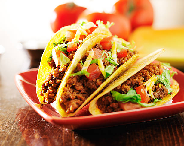 istock three beef tacos with cheese, lettuce and tomatoes 504782739