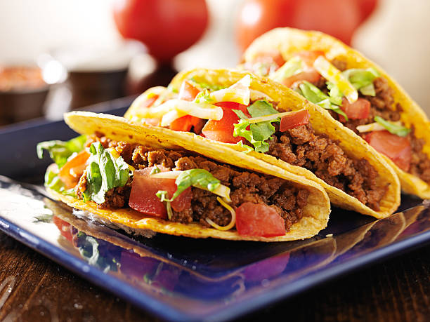 istock three beef tacos with cheese, lettuce and tomatoes 504783983