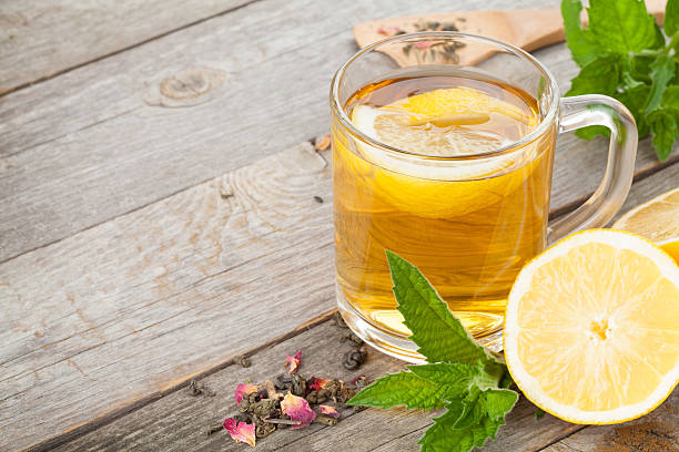 istock Green tea with lemon and mint on wooden table 504783995