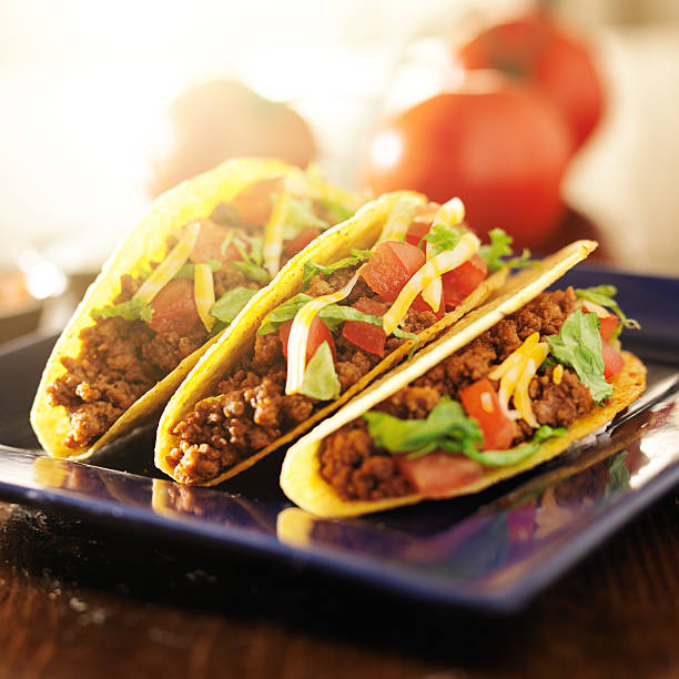 istock three beef tacos with cheese, lettuce and tomatos 504783997