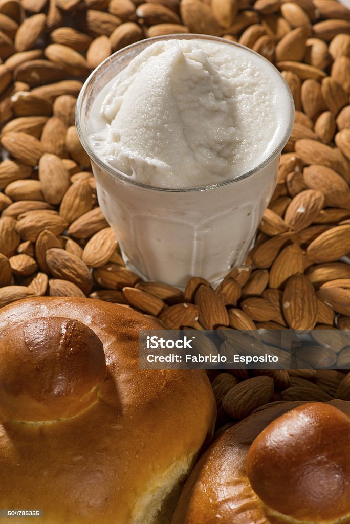Glass of almond granita Glass of almond granita, background of shelled whole almonds, 2 croissants Sicily Stock Photo
