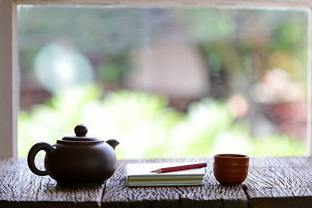 istock vintage old teapot clay cup and notebook  on wooden table 504786912