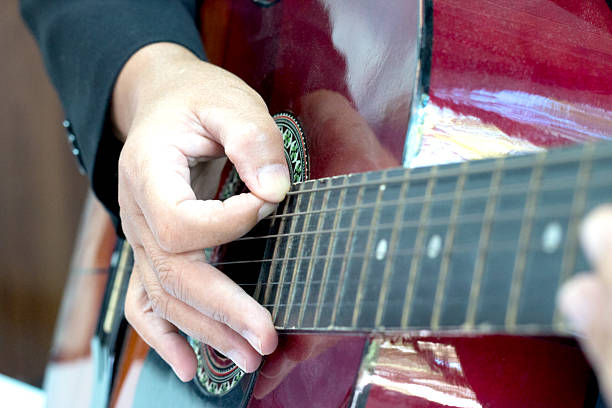 istock blurred man's hands playing acoustic guitar 504787470