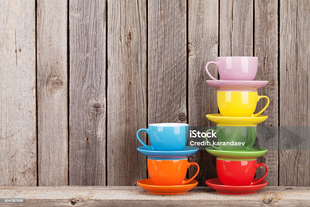Colorful coffee cups on shelf Colorful coffee cups on shelf against rustic wooden wall with copy space Cup Stock Photo