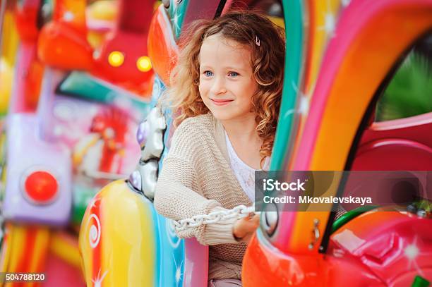 Happy Child Girl Riding Tren En Funfair Foto de stock y más banco de imágenes de Niño - Niño, Parque de atracciones, Carnaval