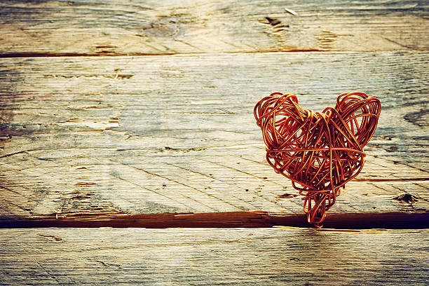 braided wire heart on old wooden planks, retro style