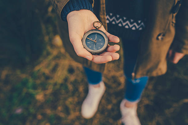 Teenager girl  holding an old compass in hand stock photo