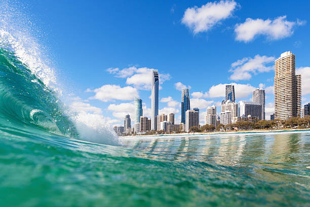 blue waves rolling on surfers paradise beach - australië stockfoto's en -beelden