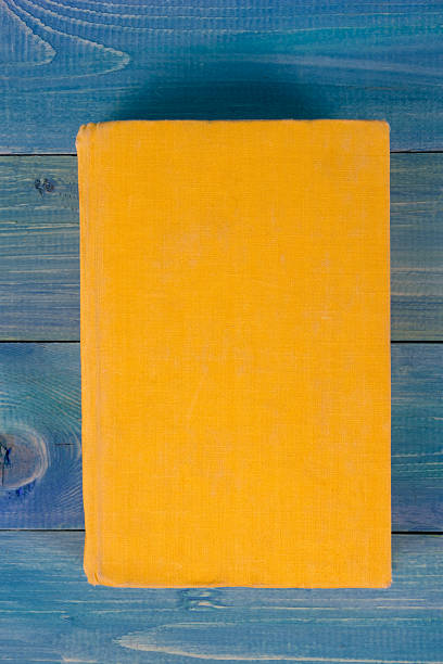 istock Yellow book on blue wooden background 504815356