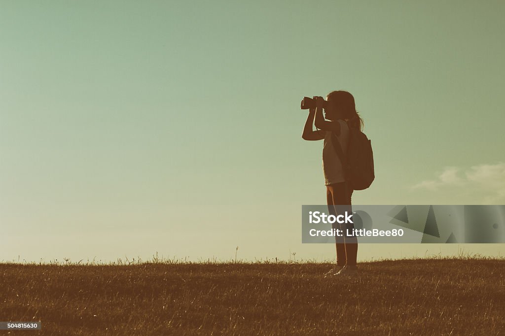 Little hiker with binoculars Cute little hiker girl looking with binoculars at sunset.Image is intentionally with grain and toned. Child Stock Photo