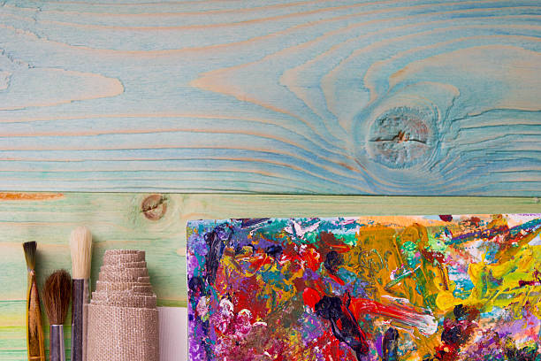 istock Colorful artistic paintbrushes, pencils on wooden deck table background 504815818