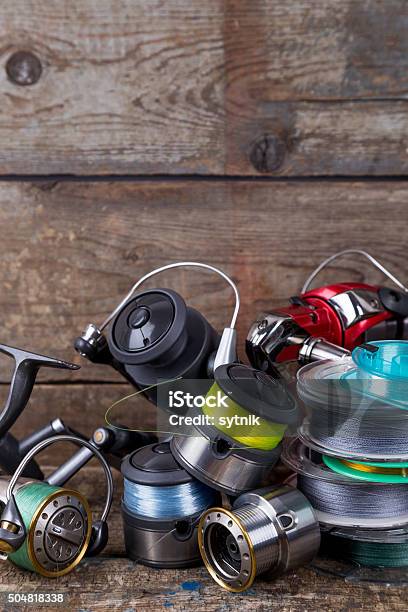 Fishing Reels And Spoole With Line On Wooden Background Stock Photo -  Download Image Now - iStock