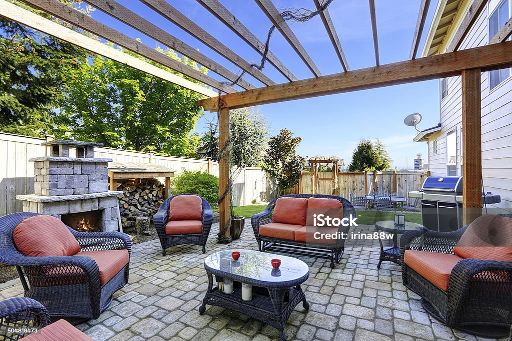 Home garden with patio area and fireplace Backyard cozy patio area with wicker furniture set and  brick fireplace Outdoors Stock Photo