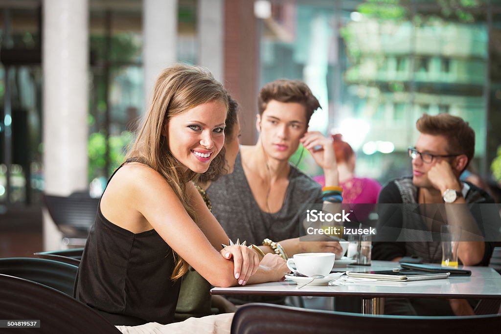 Urban young people in college cantine Cheerful young urban people sitting in college cantine. Focus on beautiful young woman smiling at camera. City Stock Photo