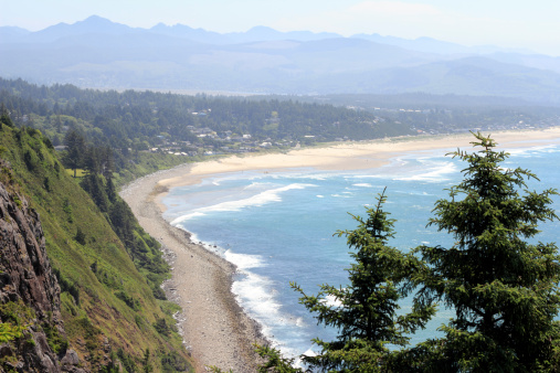 High up view from an overlook viewpoint in the Oswald West area looking towards Manzanita, Oregon on a sunny summer day.