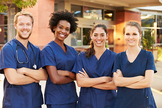 портрет медицинская команда стоя за пределами больницы - scrubs стоковые фото и изображения
