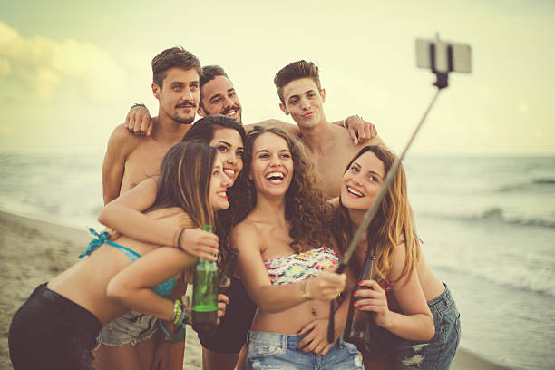 летние каникулы впечатления: селфи stick на море - shirtless beach women bikini стоковые фото и изображения