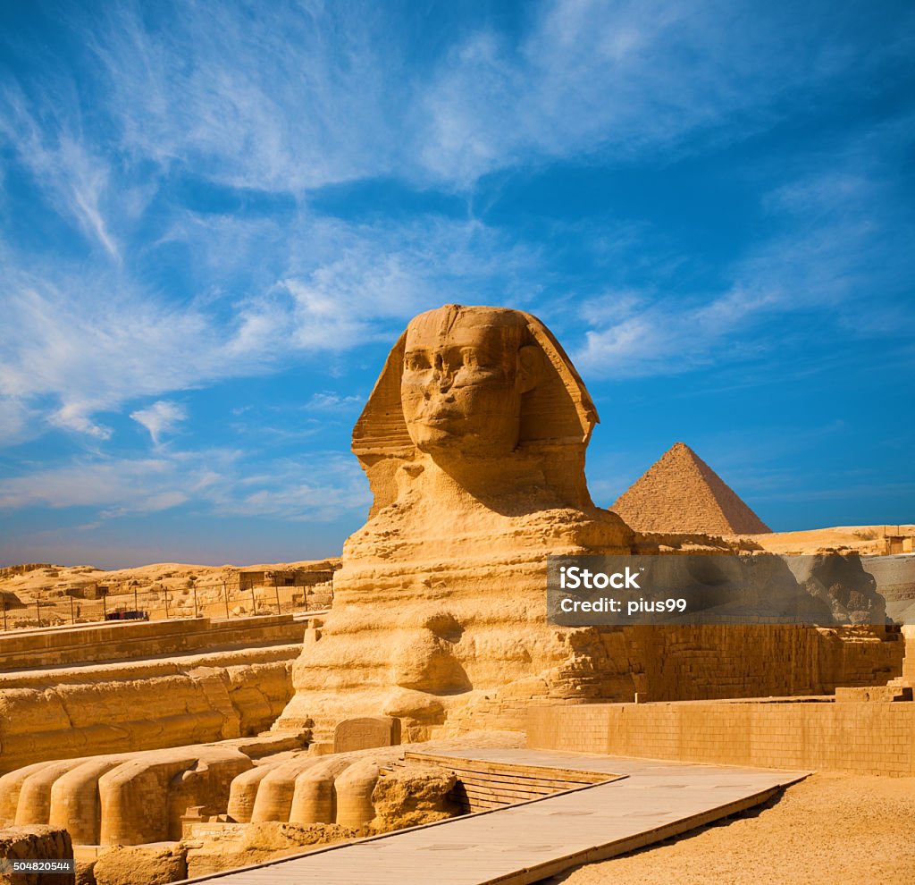 Great Sphinx Body Blue Sky Pyramid Giza Egypt Full length body profile of Great Sphinx including head, feet with great pyramid of Menkaure in background on a clear, blue sky day in Giza, Egypt empty with no people. Copy space Sphynx Hairless Cat Stock Photo
