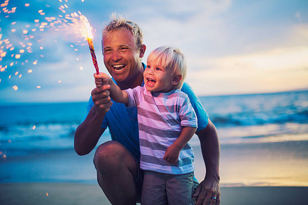 Father and son lighting fireworks stock photo