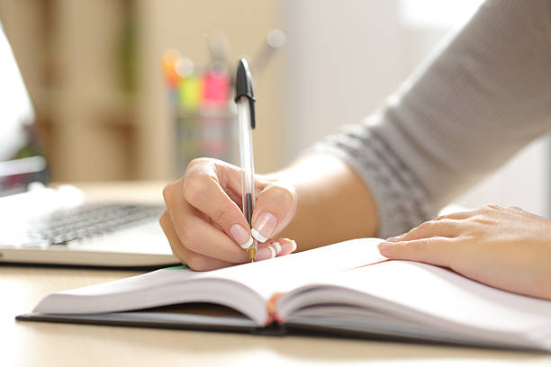 donna mano scrivendo in un ordine del giorno a casa - diary writing women human hand foto e immagini stock