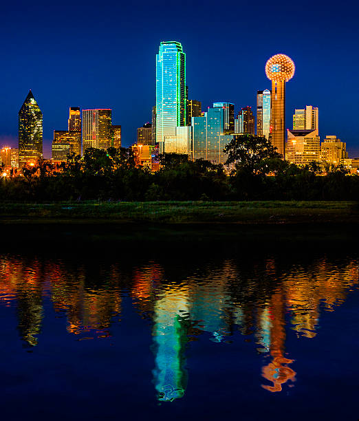 Downtown Dallas Cityscape Skyline Skyscrapers glowing at dusk / twilight The Dallas Skyline lighting up in vibrant colors just after sunset with an electric blue sky. reunion tower photos stock pictures, royalty-free photos & images