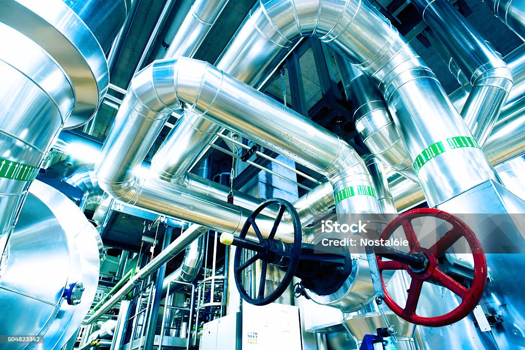 different size and shaped pipes and valves different size and shaped pipes and valves at a power plant Petrochemical Plant Stock Photo