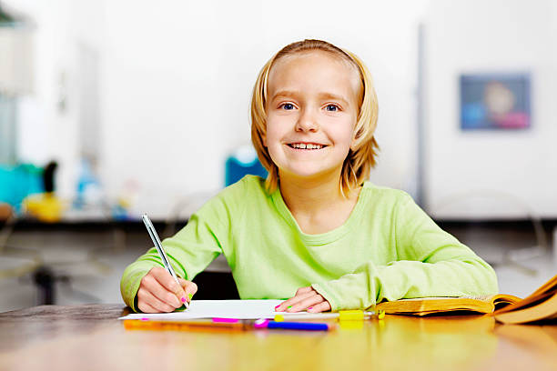 istock Cute schoolgirl enjoys doing her homework 504823449