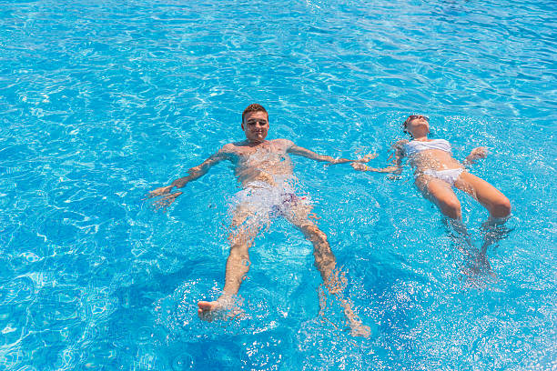 istock Young Couple Floating on Backs in Swimming Pool 504823888