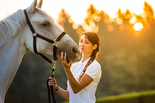 istock Young woman standing with horse 504824046