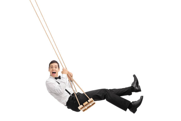 istock Elegant man swinging on a wooden swing 504824336