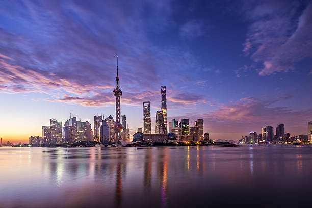 waterfront cityscape and illuminated skyline at dawn waterfront cityscape and illuminated skyline at dawn promenade shanghai stock pictures, royalty-free photos & images