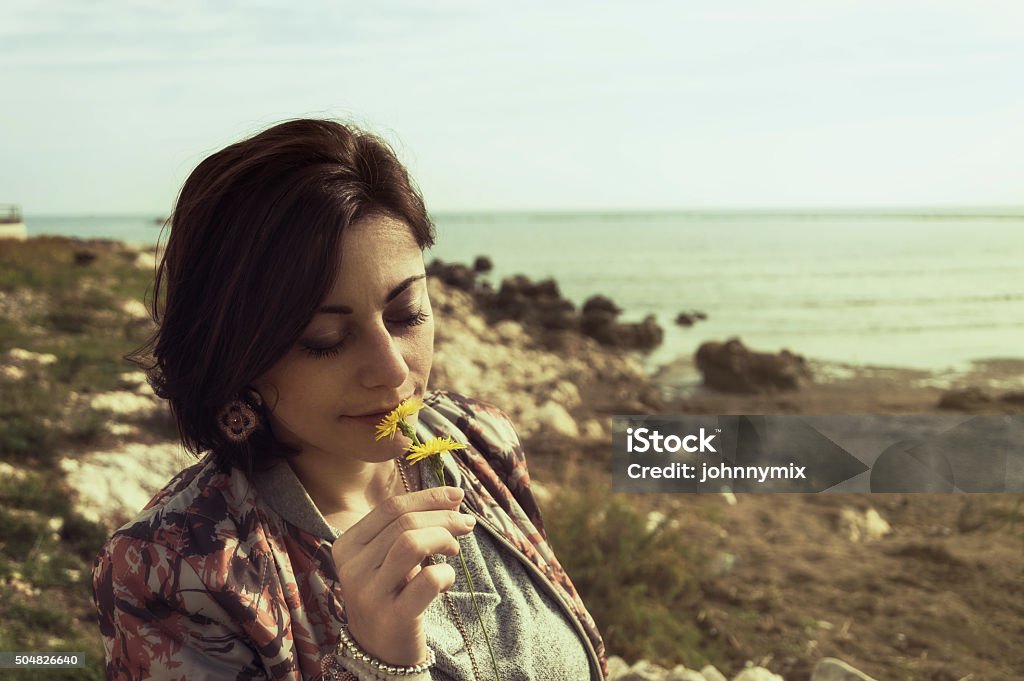 Flower and girl A girl smelling flowers Adult Stock Photo