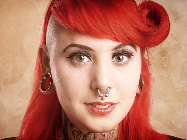 girl with piercings and tattoos young alternative woman with side cut, facial piercings and tattoos - with added texture filter effect septum piercing stock pictures, royalty-free photos & images
