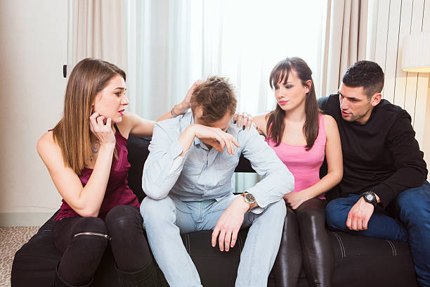 istock Young man crying and being comforted by friends 504829002