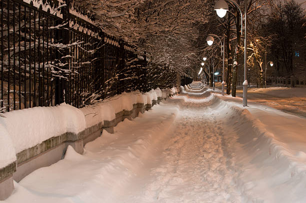 istock Snowy night pathway in city. Horizontal view 504829840