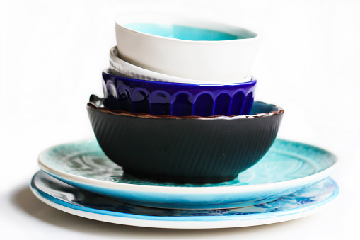 Stack of blue and white plates and bowls isolated on white background.