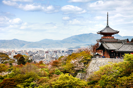 Kyoto, Japan – March 14, 2013: The Kiyomizu-dera Buddhist Temple grounds and the skyline of Kyoto, Japan on an autumn day. 