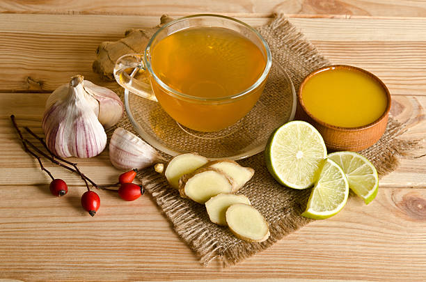 Taza de té con porciones de limón y jengibre - foto de stock
