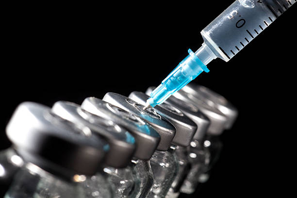 Glass Medicine Vials and Syringe on black background stock photo
