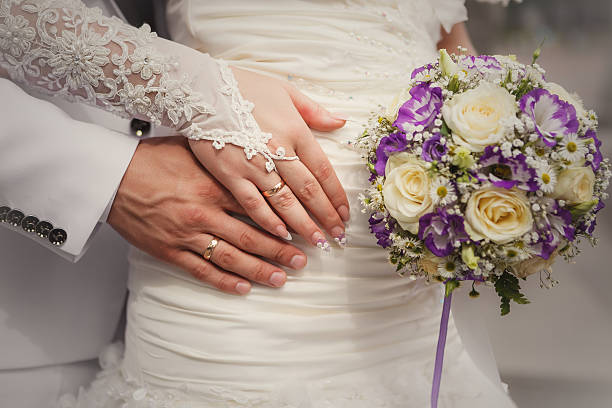 istock Bride and groom's hands with wedding bouquet and rings 504853810