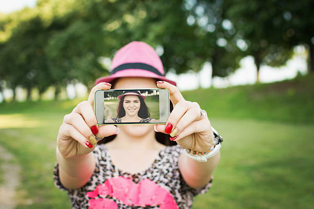 Moda Joven mujer tomando un autorretrato en park - foto de stock