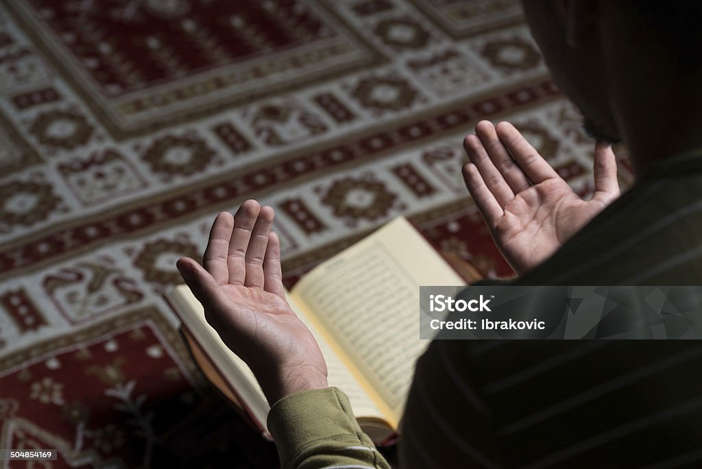 이슬람교도 남자 독서모드 이 코란 - 로열티 프리 기도하기 스톡 사진
